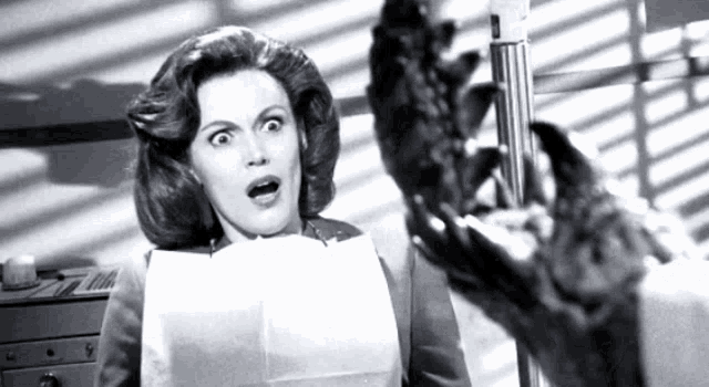 a woman with a surprised look on her face holds a piece of paper