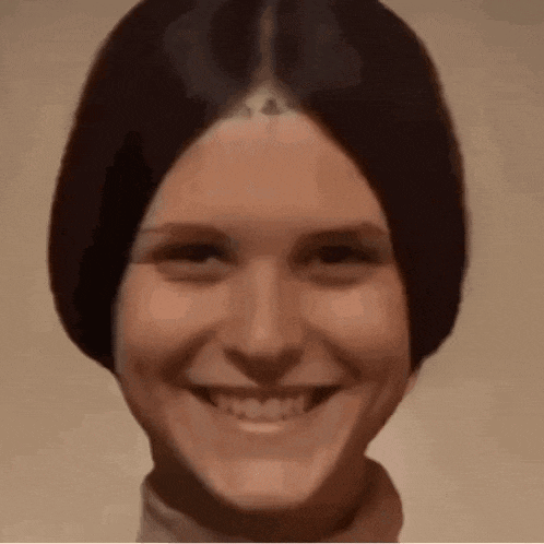 a close up of a woman 's face with a smile