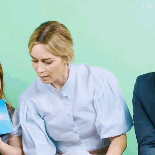 a woman with a surprised look on her face is sitting next to a man in a suit and a girl