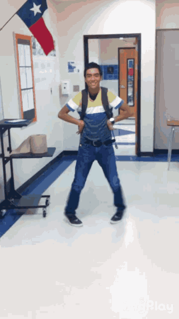 a man with a backpack is standing in a hallway with a texas flag in the background