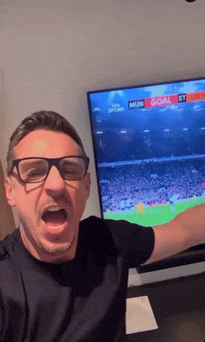a man wearing glasses is standing in front of a tv that says ' mun goal ' on it