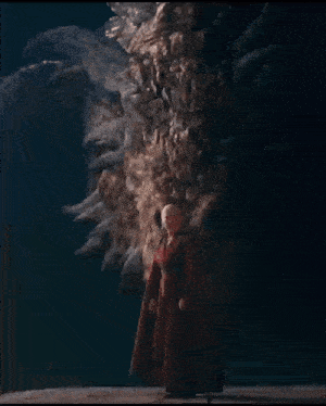 a man in a red cape is standing in front of a dragon