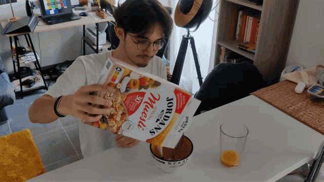 a man is pouring cereal into a bowl from a box that says jordans muesli