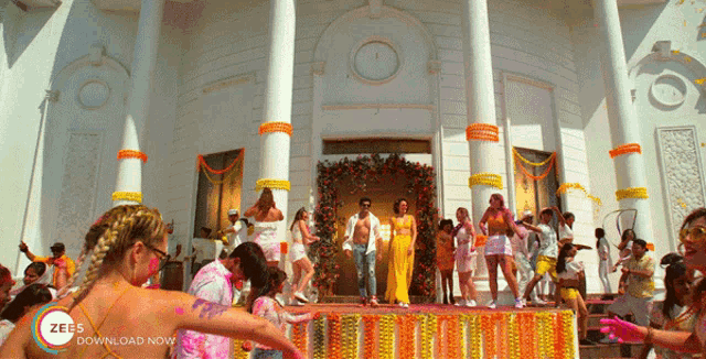 a group of people dancing in front of a building that says zees