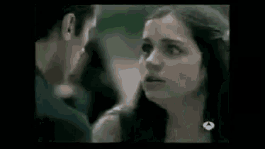 a man and a woman are kissing each other in a dark room .