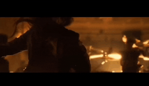 a group of people are playing drums in a dark room with a lot of lights .