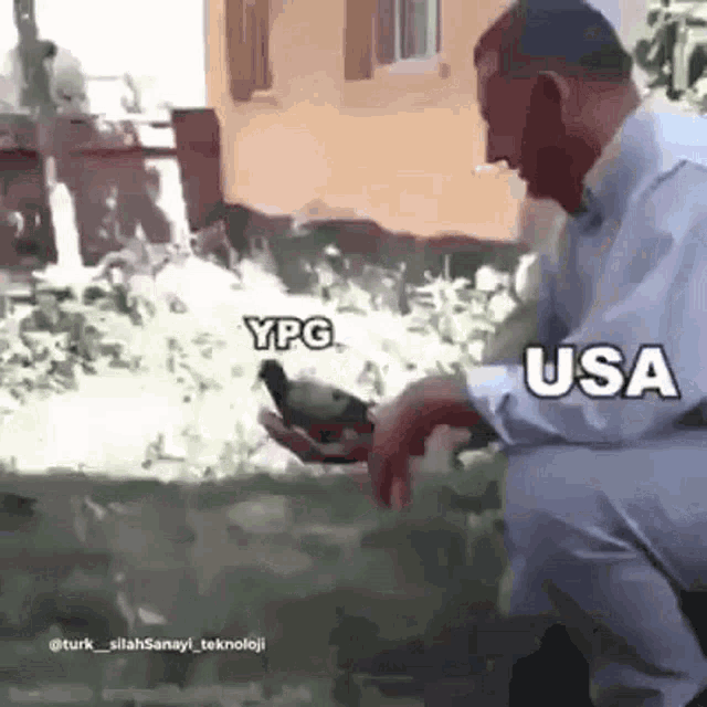 a man is kneeling down holding a pigeon in his hands with the words usa and ypg written on the bottom