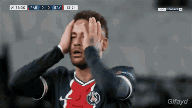 a soccer player covering his eyes with his hands during a match