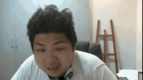 a man wearing headphones is sitting in a chair in front of a computer screen .