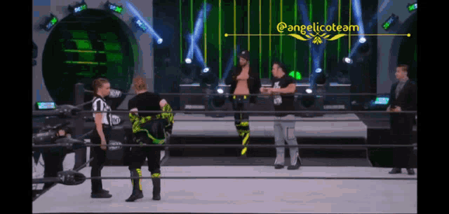 a group of wrestlers are standing in a ring with a sign that says angelicoteam above them