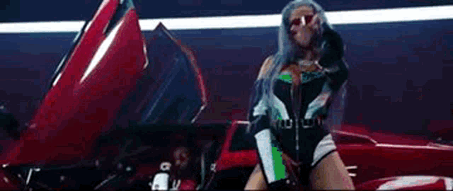 a woman in a bodysuit is standing next to a red car with the hood open .