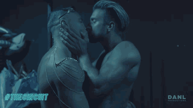 two men kissing in a dark room with #the circuit written on the bottom right