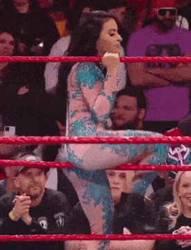 a woman in a wrestling ring is wearing a purple shirt that says snp