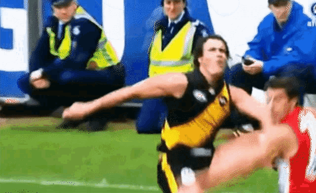 a man in a yellow jersey is kicking another man in a red jersey
