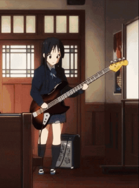 a girl in a school uniform is playing a bass guitar in a room