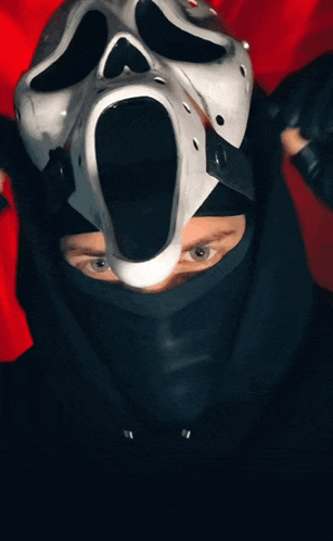 a man wearing a scream mask and a black hoodie