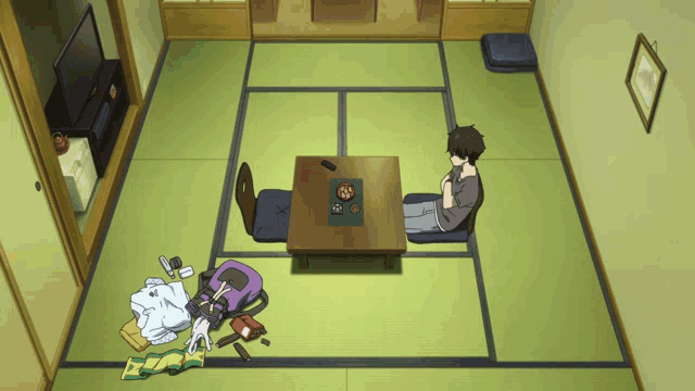 a man sits on the floor in front of a small table