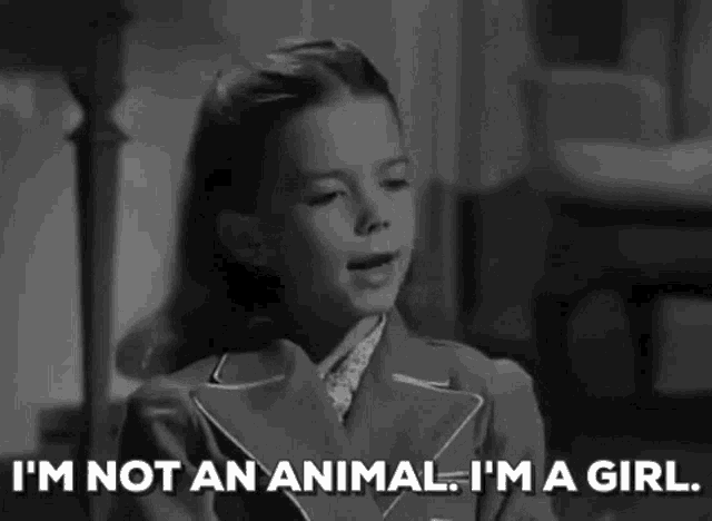 a black and white photo of a girl saying `` i 'm not an animal , i 'm a girl ''