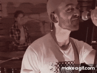 a man in a vans shirt is singing into a microphone ..