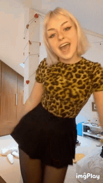a girl wearing a leopard print shirt and black skirt