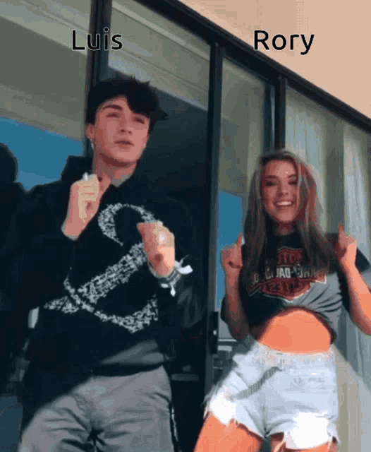 a man and a woman are dancing in front of a window with the words luis and rory written above them