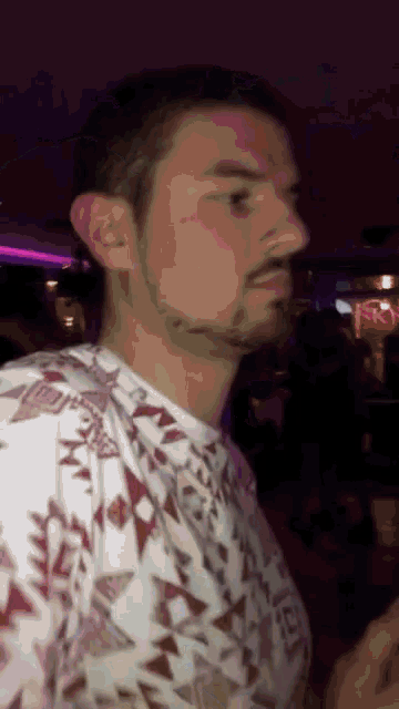 a man with a beard is wearing a shirt with a pattern