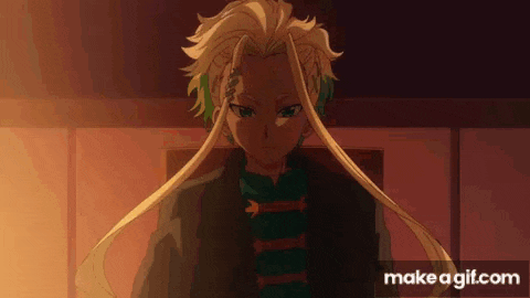 a boy with long blonde hair is sitting in a chair in a room .