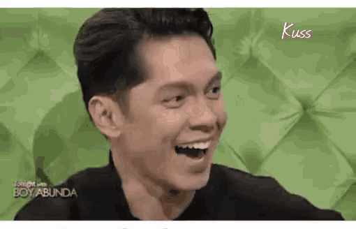 a close up of a man 's face with his mouth open and a green background .