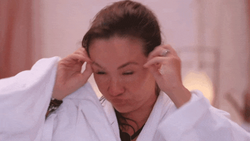 a woman wearing a white robe is making a face