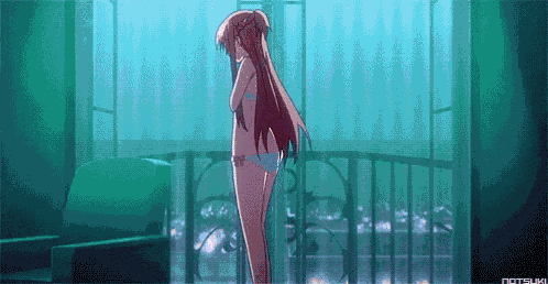 a girl in a bikini is standing on a balcony with a chair in the background .