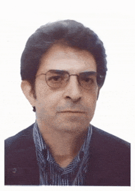 a man wearing glasses and a plaid shirt is looking at the camera