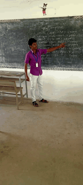 a man in a purple shirt stands in front of a blackboard that says ' impossible ' on it