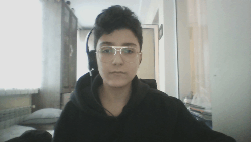 a young man wearing glasses and headphones is looking at the camera