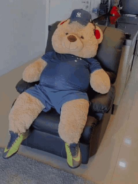 a teddy bear wearing a ny hat sits on a chair