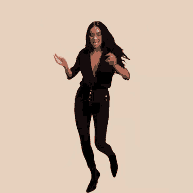a woman in a black dress is jumping in the air with her arms in the air .