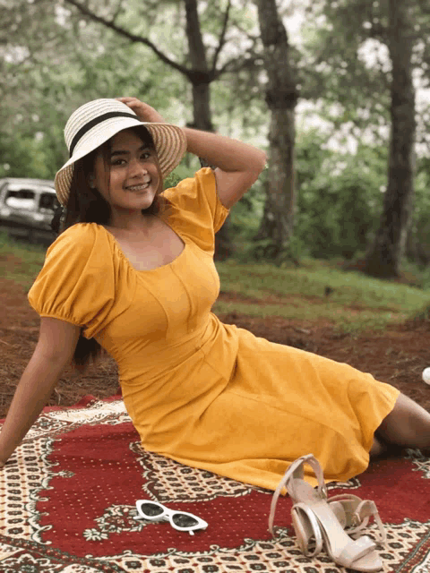a woman in a yellow dress sits on a red rug