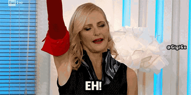a woman is holding up a red glove and saying eh .
