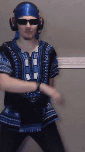 a man wearing sunglasses and headphones is dancing in a blue shirt