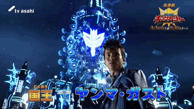 a man in a blue jacket stands in front of a screen that says ' tv asahi ' on it