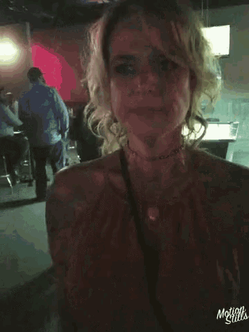 a woman is standing in front of a pool table in a dark room with motion stills written on the bottom