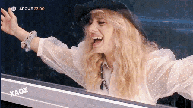 a woman in a cowboy hat is waving her hand in front of a screen that says aouve 23:00