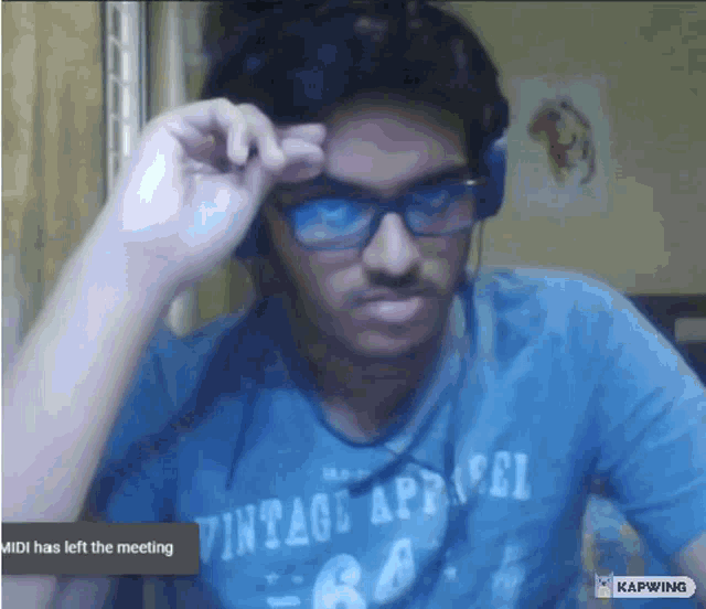 a man wearing headphones and a vintage apparel shirt is on a video call