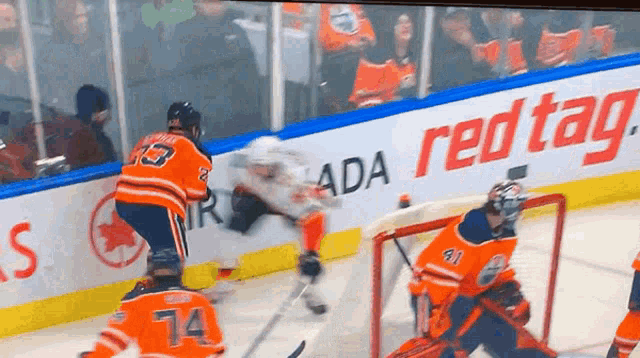 a hockey game is being played in front of an ad for redtag