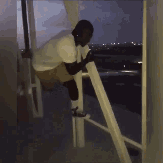 a man in shorts is leaning against a railing