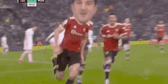 a soccer player with a face on his jersey is running on a soccer field .