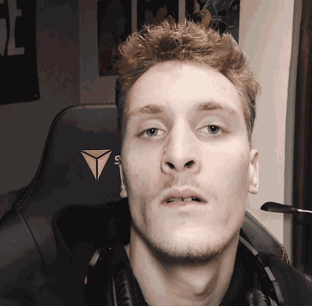 a man wearing headphones is sitting in a gaming chair with the letter s on it