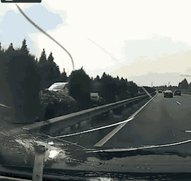 a car with a broken windshield is driving down the road