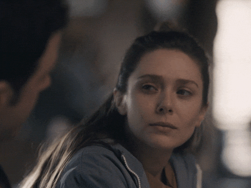 a woman in a blue sweatshirt is looking at a man