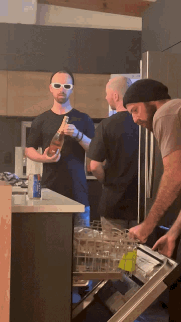 a man in sunglasses holds a bottle of wine while another man looks on