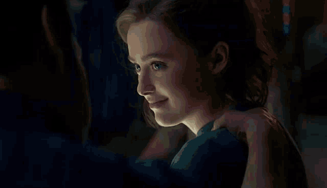 a woman is smiling while a man holds her shoulder .